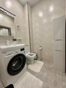 La salle de bains est pourvue d'un lave-linge et de toilettes. dans l'établissement Apartment in Tashkent City Center, à Yakkasaray