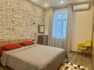 - une chambre avec un lit et un mur en briques dans l'établissement Apartment in Tashkent City Center, à Yakkasaray