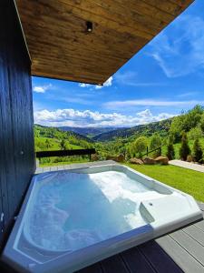 a hot tub on a deck with a view at Bacówki Resort in Ochotnica Górna