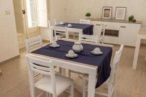 a kitchen and dining room with a table and chairs at B&B Badimà in Fleri