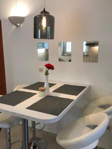 Apartmani Samec في نوفاليا: طاولة مع مزهرية عليها زهرة حمراء