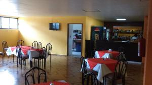 um restaurante com mesas e cadeiras vermelhas e brancas em Hotel Aeropuerto em Toluca