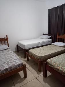 a room with three beds in a room at Casa 11 hóspedes Temporada em Ribeirão in Ribeirão Preto