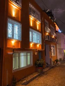 un bâtiment avec des fenêtres éclairées sur une rue la nuit dans l'établissement IMMOR AKKUS HOTEL, à Istanbul