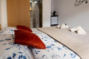 dwie czerwone poduszki siedzące na łóżku w obiekcie Sant' Elena Room w mieście Bale