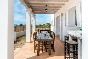 a dining room with a table and chairs on a patio at Casa Es Vedrà in Cala Saona