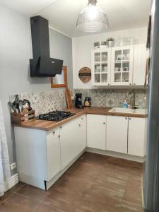 a kitchen with white cabinets and a stove top oven at Maison de 2 chambres avec jardin clos et wifi a Vierzon in Vierzon