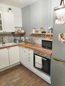 a kitchen with white cabinets and a stainless steel refrigerator at Maison de 2 chambres avec jardin clos et wifi a Vierzon in Vierzon