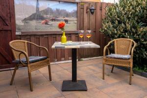 a table with two chairs and a vase with wine glasses at Het Zomerhuis in Egmond-Binnen