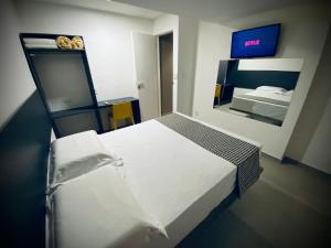 1 dormitorio con 1 cama blanca grande y espejo en Sun Smart Hotel -, en Recife