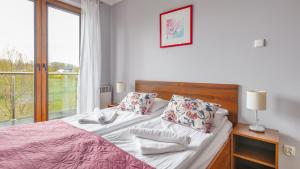 een slaapkamer met een bed en een raam bij Rozewie, Sun & Snow in Jastrzębia Góra
