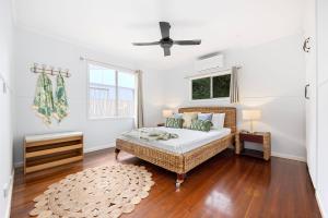 um quarto com uma cama e uma ventoinha de tecto em Vila Paus Dua - Beachfront Hervey Bay em Hervey Bay