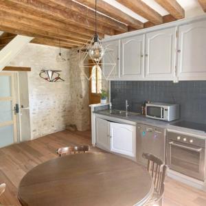 cocina con mesa y microondas en Maison de 2 chambres avec jardin clos a Montlognon, 