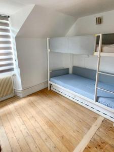 a room with two bunk beds and a wooden floor at Maison de 2 chambres avec jardin clos a Montlognon 
