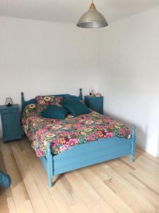 a bedroom with a blue bed with a floral bedspread at Maison de 2 chambres avec vue sur la ville et jardin clos a Vimenet 