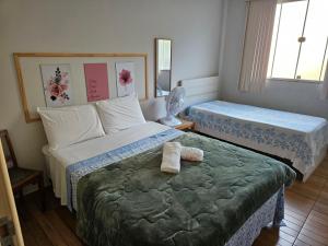ein Schlafzimmer mit 2 Betten und Handtüchern darauf in der Unterkunft casa/apartamento centro Santa Teresa-ES in Santa Teresa