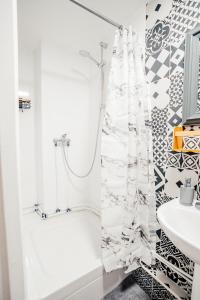 a white bathroom with a shower curtain and a sink at Merveilleux studio à côté de Paris et Disney in Neuilly-Plaisance +5 photos