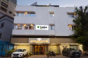 um edifício com um carro estacionado em frente em Treebo Trend Ambassador em Ahmedabad