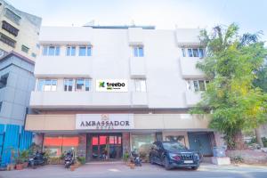 a building with a car parked in front of it at Treebo Trend Ambassador in Ahmedabad