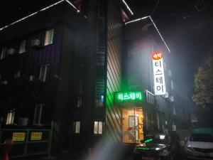 un bâtiment avec un panneau sur son côté la nuit dans l'établissement T stay guesthouse, à Cheongju