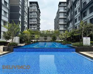 una piscina en medio de algunos edificios de apartamentos en Kamalinda Haven: 3BR/2BA - Steps Away for 5pax, en Shah Alam