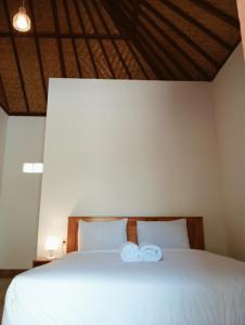 een slaapkamer met een bed met twee handdoeken erop bij Jepun Homestay Lemukih in Singaraja