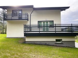 a white house with a balcony and grass at Willa Platanowe Wzgórze in Wojcieszyce +66 photos