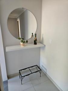 een badkamer met een spiegel en een plank met een fles wijn bij casa/apartamento centro Santa Teresa-ES in Santa Teresa