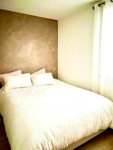 - une chambre avec un lit blanc et une fenêtre dans l'établissement Cosy et Raffiné-Proche Village Olympique et Métro, à Clichy