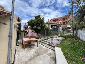 a patio with a wooden table and some buildings at Nonas House in Kanoni
