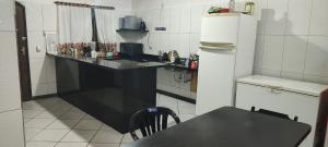 a kitchen with a black counter and a refrigerator at Argentina House in Sao Paulo