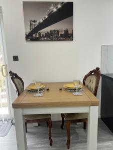 a wooden table with two plates and glasses on it at Beautiful maisonette in Leeds