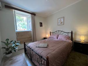 a bedroom with a bed with pink pillows and a window at Nonas House in Kanoni