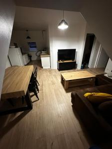 a living room with a table and a couch at La nouvelle école in Ruillé-en-Champagne
