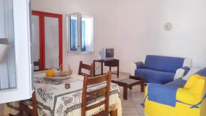 een woonkamer met een blauwe bank en een stoel bij 2 bedrooms house at Marsala 250 m away from the beach with sea view and furnished garden in Trapani