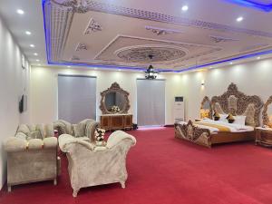 a bedroom with a bed and chairs and a bed and a bed and a bed at Niagara Falls Bahawalpur in Bahawalpur