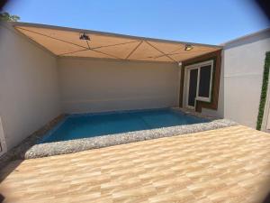 una piscina in una stanza con soffitto di شاليهات الرويلي a Al Fayşalīyah