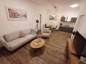 a living room with a couch and a table at Ferienapartment Zur Bunten Kuh Walporzheim in Bad Neuenahr-Ahrweiler
