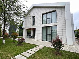 a white house with black windows at Arena Villas Guba in Quba