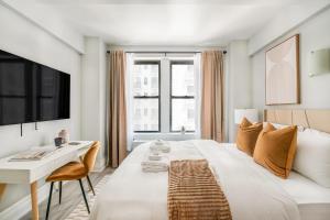a white bedroom with a large bed and a desk at 73-1104 New Studio UWS Doorman Gym in New York