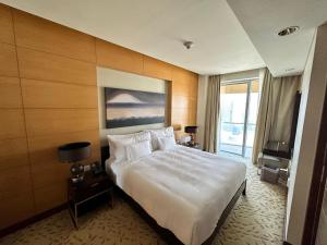 ein Hotelzimmer mit einem großen Bett und einem großen Fenster in der Unterkunft Emaar Fashion avenue-Formerly The Address Dubai Mall residence - Downtown-Suitestay in Dubai