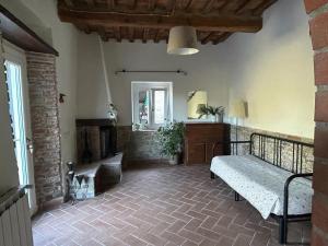- un salon avec un lit et une cheminée dans l'établissement La Casa Del Tiglio, à Borgo San Lorenzo