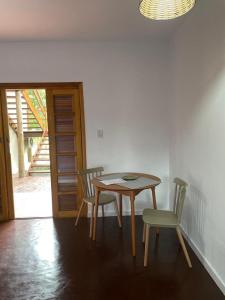 a table and chairs in a room with a window at Vila Guaraú in Peruíbe +8 photos