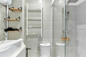 ein Bad mit einer Dusche, einem WC und einem Waschbecken in der Unterkunft Charming 1 bedroom flat Coeur du Marais By Studio Prestige in Paris