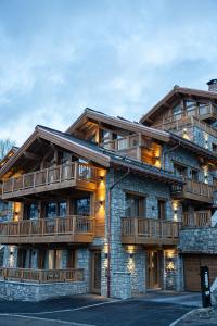 un gran edificio con balcones de madera. en Falcon Lodge by Alpine Residences en Méribel