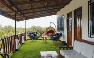 uma varanda com cadeiras e um baloiço em Perfect Beach House In Kigamboni em Dar es Salaam