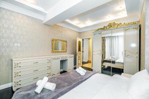 a bedroom with a large bed and a mirror at Park Azure Deluxe Apartment By Baku Housing in Baku