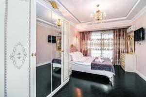um quarto com uma cama e um espelho em Park Azure Deluxe Apartment By Baku Housing em Baku