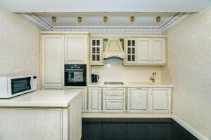 a kitchen with white cabinets and a microwave at Park Azure Deluxe Apartment By Baku Housing in Baku