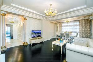 a living room with a couch and a tv at Park Azure Deluxe Apartment By Baku Housing in Baku